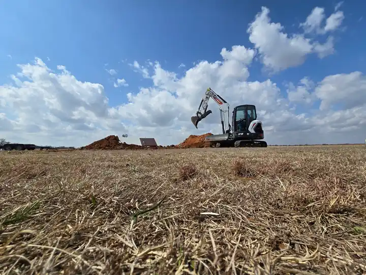 Large excavator digging a residential pond on Oklahoma rural property